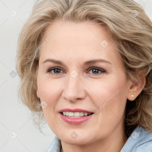 Joyful white adult female with medium  brown hair and blue eyes