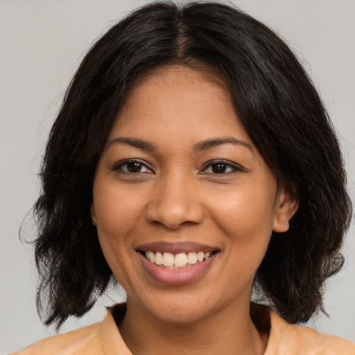 Joyful latino young-adult female with medium  brown hair and brown eyes