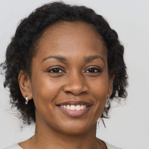 Joyful black adult female with medium  brown hair and brown eyes