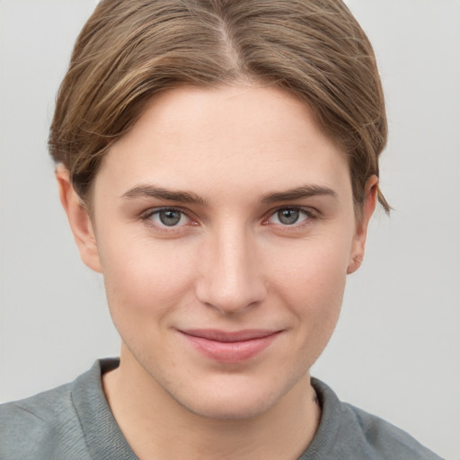 Joyful white young-adult female with short  brown hair and grey eyes