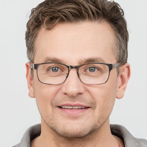 Joyful white adult male with short  brown hair and grey eyes