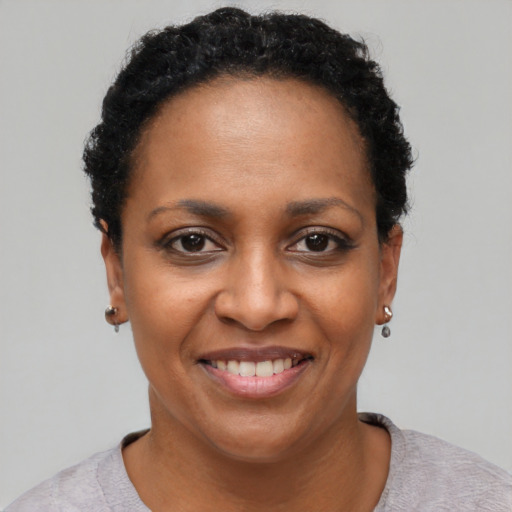 Joyful black adult female with short  black hair and brown eyes