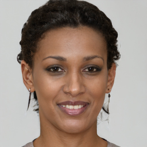 Joyful black young-adult female with short  brown hair and brown eyes