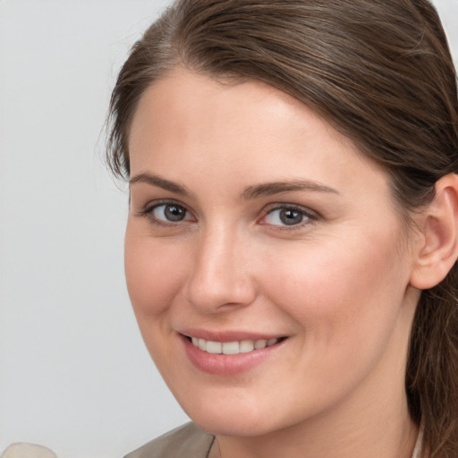 Joyful white young-adult female with medium  brown hair and grey eyes