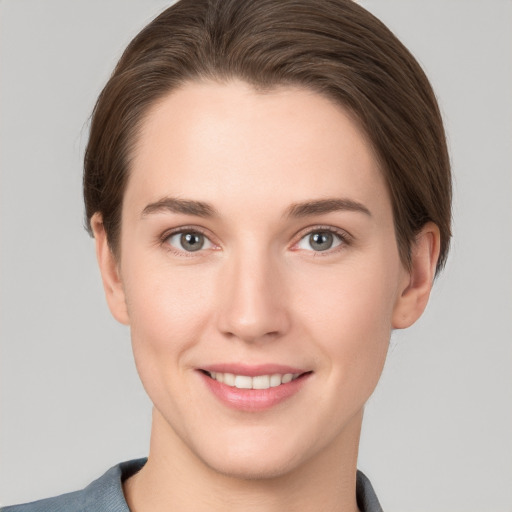 Joyful white young-adult female with short  brown hair and grey eyes