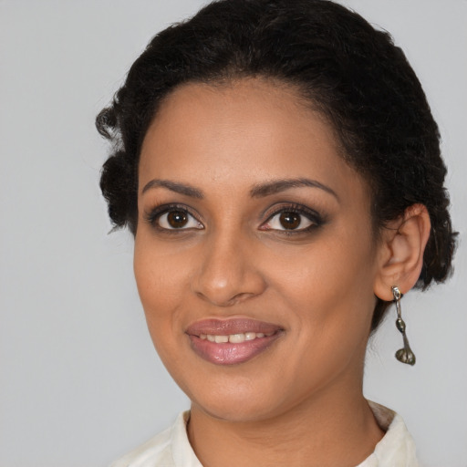 Joyful black young-adult female with medium  brown hair and brown eyes