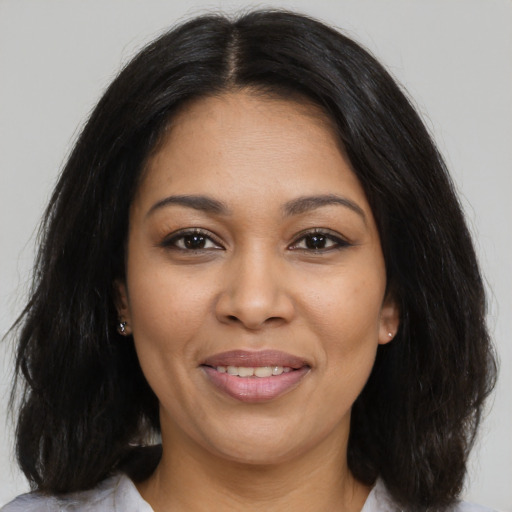 Joyful latino young-adult female with medium  brown hair and brown eyes