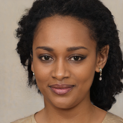 Joyful black young-adult female with long  black hair and brown eyes