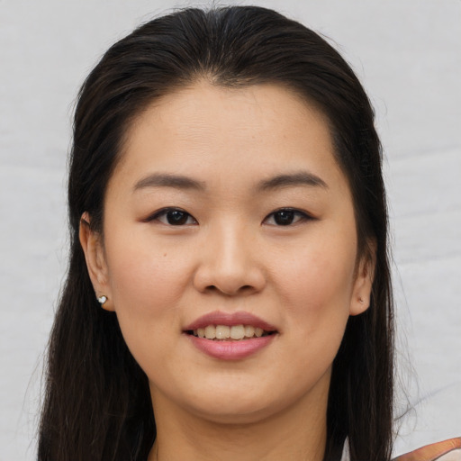 Joyful asian young-adult female with long  brown hair and brown eyes