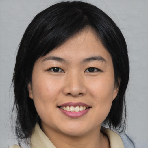 Joyful asian young-adult female with medium  black hair and brown eyes