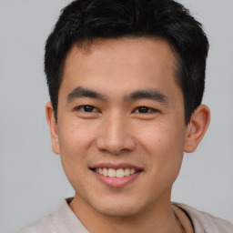 Joyful asian young-adult male with short  black hair and brown eyes