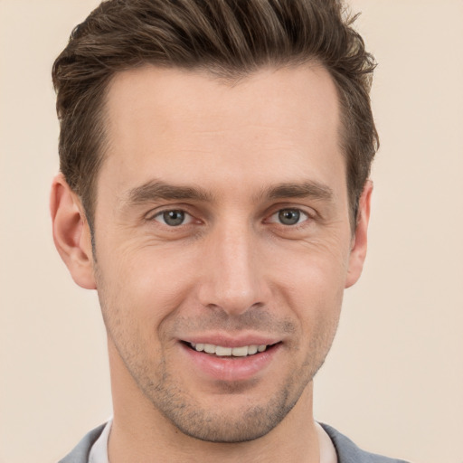 Joyful white young-adult male with short  brown hair and grey eyes