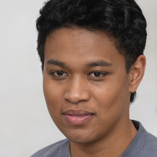 Joyful black young-adult male with short  black hair and brown eyes