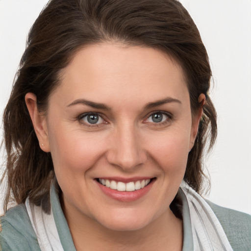 Joyful white young-adult female with medium  brown hair and grey eyes