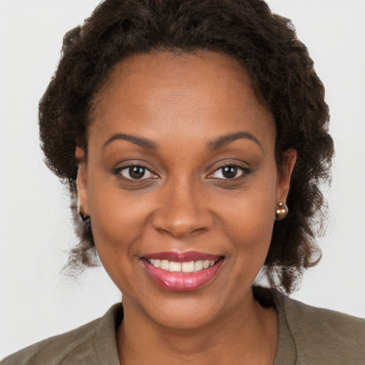 Joyful black young-adult female with medium  brown hair and brown eyes