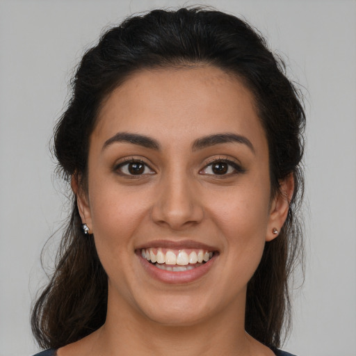 Joyful latino young-adult female with long  brown hair and brown eyes