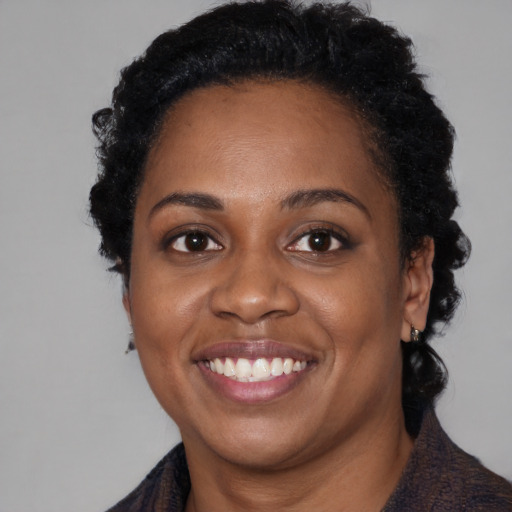 Joyful black adult female with medium  black hair and brown eyes