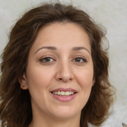 Joyful white young-adult female with long  brown hair and green eyes