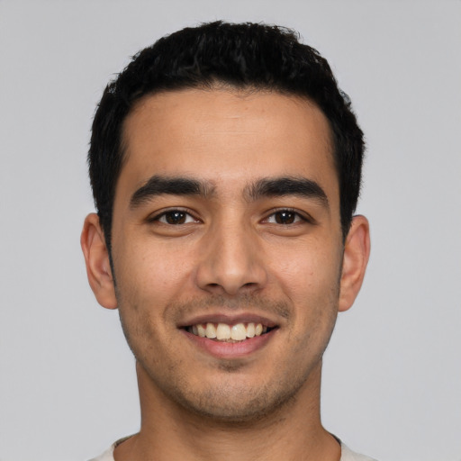 Joyful latino young-adult male with short  black hair and brown eyes