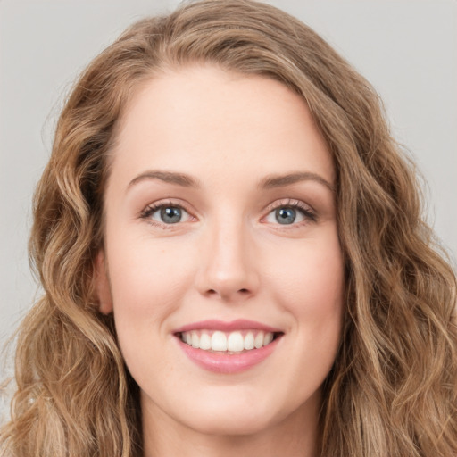 Joyful white young-adult female with long  brown hair and green eyes