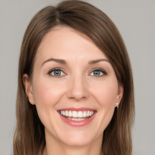 Joyful white young-adult female with long  brown hair and green eyes