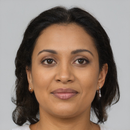 Joyful latino adult female with medium  brown hair and brown eyes