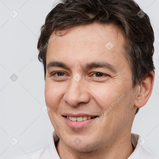 Joyful white adult male with short  brown hair and brown eyes