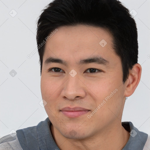 Joyful asian young-adult male with short  black hair and brown eyes