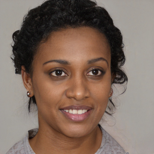 Joyful black young-adult female with medium  brown hair and brown eyes