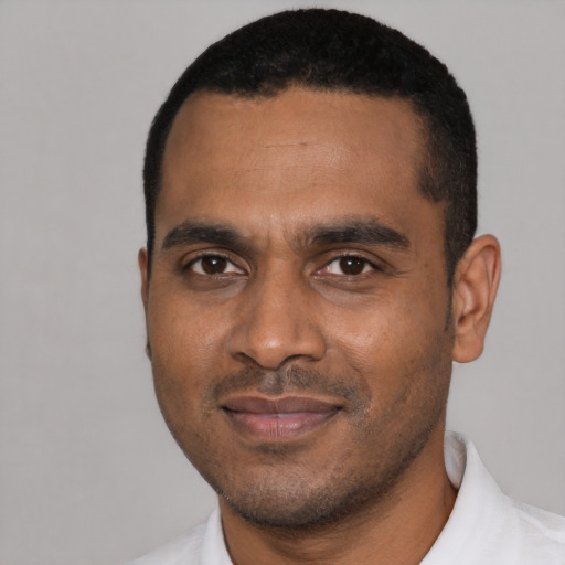 Joyful black young-adult male with short  black hair and brown eyes