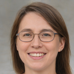 Joyful white adult female with medium  brown hair and blue eyes