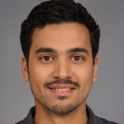 Joyful latino young-adult male with short  black hair and brown eyes