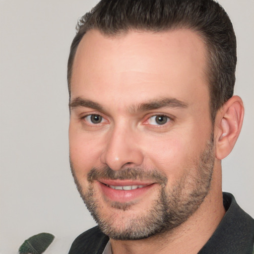 Joyful white adult male with short  brown hair and brown eyes