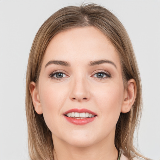 Joyful white young-adult female with medium  brown hair and grey eyes