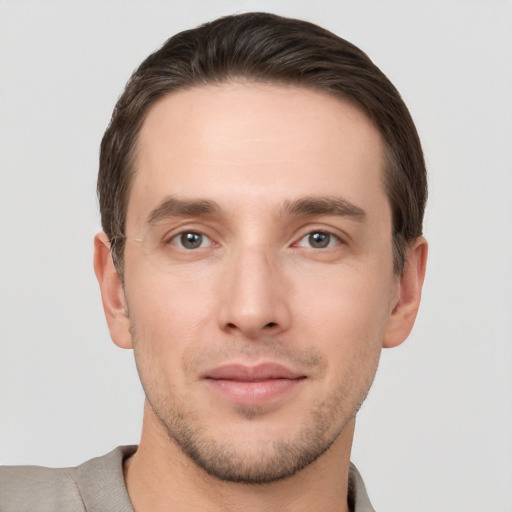 Joyful white young-adult male with short  brown hair and grey eyes