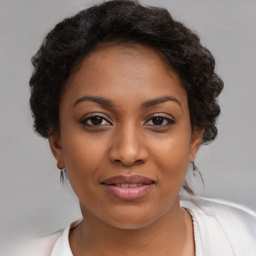 Joyful black young-adult female with short  brown hair and brown eyes