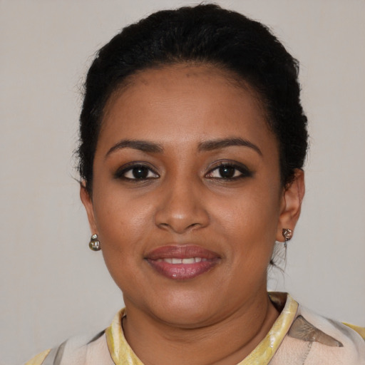 Joyful black young-adult female with short  brown hair and brown eyes