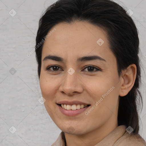 Joyful latino young-adult female with long  brown hair and brown eyes