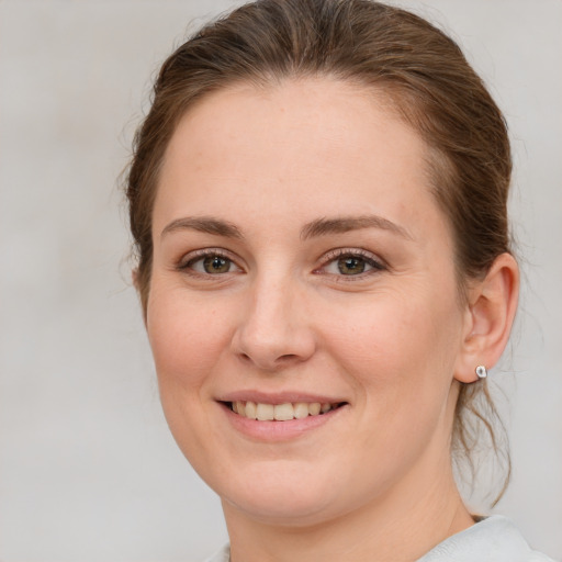 Joyful white young-adult female with medium  brown hair and green eyes