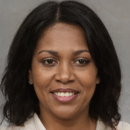 Joyful black adult female with medium  brown hair and brown eyes