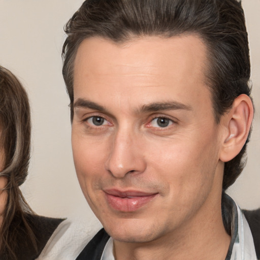 Joyful white adult male with medium  brown hair and brown eyes