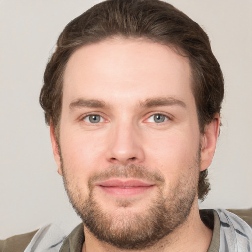 Joyful white young-adult male with short  brown hair and grey eyes