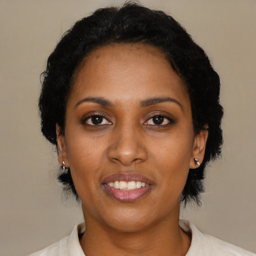 Joyful black young-adult female with short  black hair and brown eyes