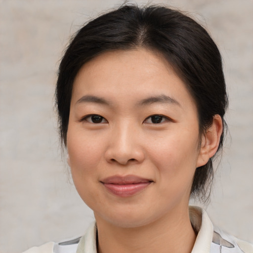 Joyful asian young-adult female with medium  brown hair and brown eyes