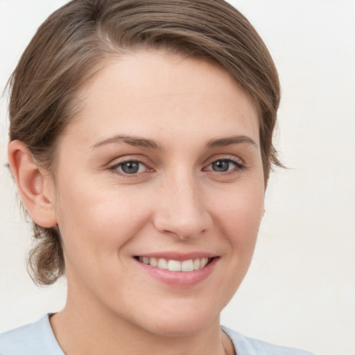 Joyful white young-adult female with medium  brown hair and grey eyes