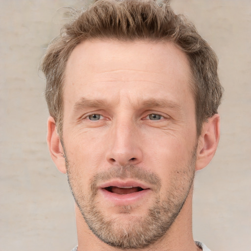 Joyful white adult male with short  brown hair and grey eyes