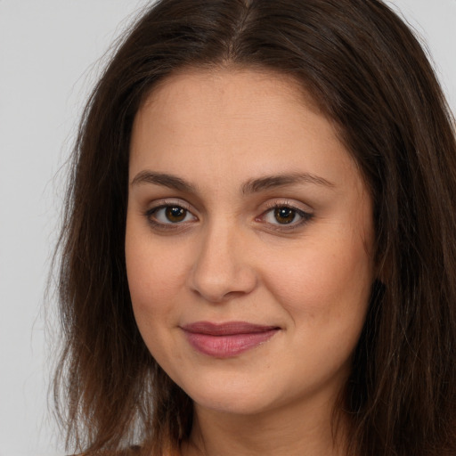 Joyful white young-adult female with long  brown hair and brown eyes