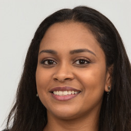 Joyful latino young-adult female with long  brown hair and brown eyes