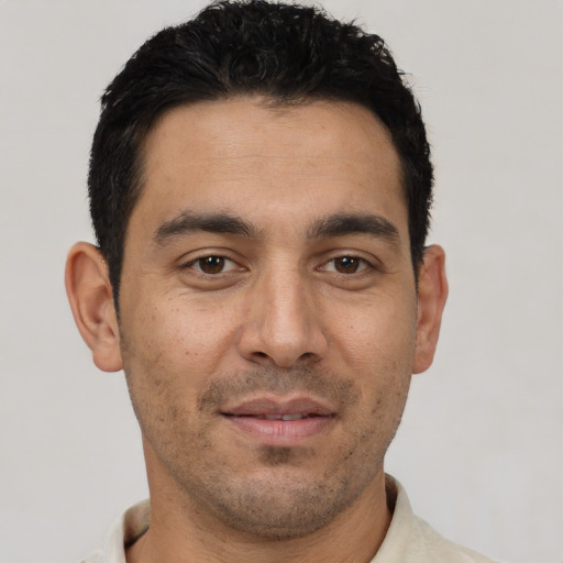 Joyful white young-adult male with short  black hair and brown eyes