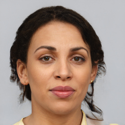 Joyful latino adult female with medium  brown hair and brown eyes